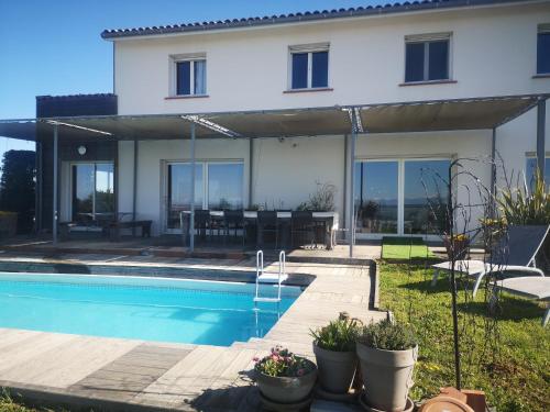 ein Haus mit Pool davor in der Unterkunft Villa piscine avec vue exceptionnelle in Puéchoursi