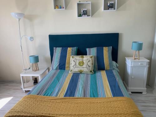 Bett mit blauem Kopfteil in einem Schlafzimmer in der Unterkunft Villa piscine avec vue exceptionnelle in Puéchoursi