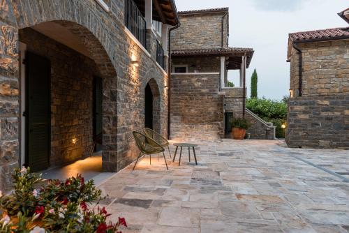 a patio with a chair and a table in a building at L'Abbraccio della Quercia - Suites in Buje