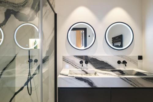 une salle de bain avec deux lavabos et deux miroirs dans l'établissement Les DUNES 3 BEDS CROISETTE BEACHES Sea VIEW, à Cannes