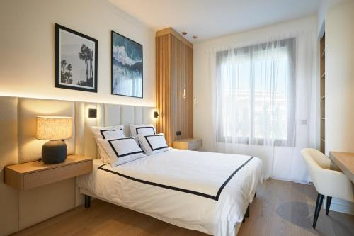 une chambre avec un grand lit blanc et une fenêtre dans l'établissement Les DUNES 3 BEDS CROISETTE BEACHES Sea VIEW, à Cannes