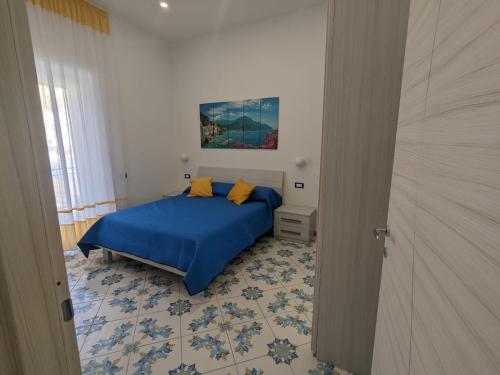1 dormitorio con 1 cama con sábanas azules y almohadas amarillas en Mamma Giovanna, en Maiori
