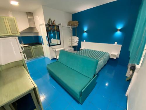 um quarto azul com um sofá verde em Estúdio Berlenga na Nazaré