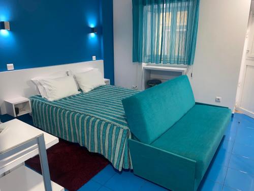 a small room with a bed and a chair at Estúdio Berlenga in Nazaré