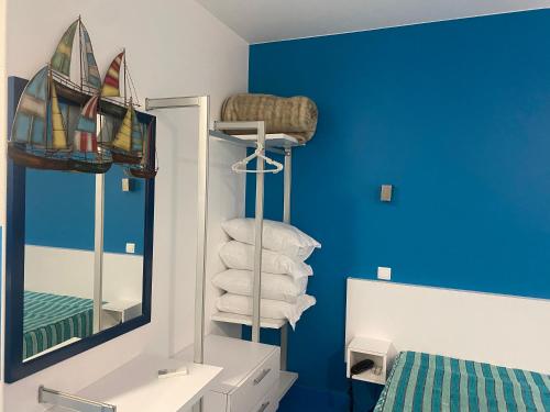 a bathroom with blue walls and a mirror and a bed at Estúdio Berlenga in Nazaré