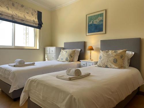 um quarto com 2 camas e toalhas em Palm Garden em Vilamoura