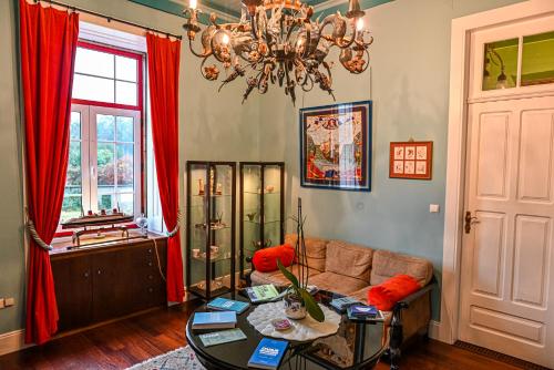 uma sala de estar com um sofá e um lustre em Vintage Balcony Guesthouse em Ovar