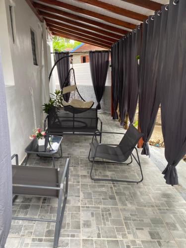 eine Terrasse mit 2 Stühlen und einem Tisch in der Unterkunft COIN D ARMANTINE in Capesterre-Belle-Eau