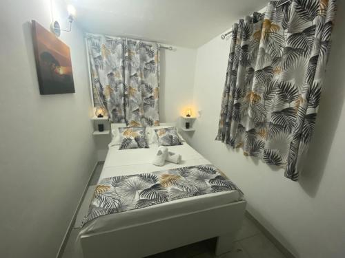 um pequeno quarto com uma cama num quarto em COIN D ARMANTINE em Capesterre-Belle-Eau