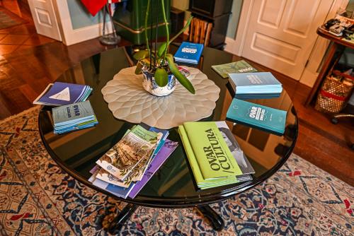 a glass coffee table with books on top of it at Vintage Balcony Guesthouse in Ovar