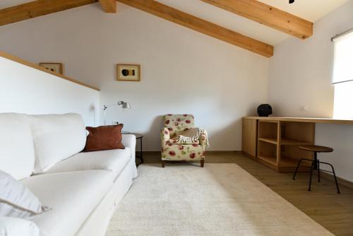 a living room with a white couch and a chair at L'Abbraccio della Quercia - Suites in Buje