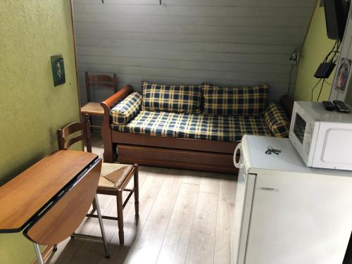 un petit salon avec un canapé et un micro-ondes dans l'établissement Le studio d Antan, à Saint-Chamant