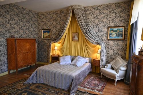 une chambre avec un lit et une chaise dans l'établissement Location meublé de tourisme La Rose des Fables, à Château-Thierry