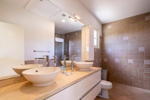 a bathroom with two sinks and a toilet at Luxury Pool Villa with View Cabana BBQ 3minBeach in Tierra del Sol in Malmok
