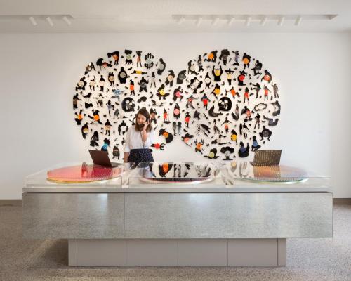 a woman standing in front of a heart made of shoes at 21c Museum Hotel Durham in Durham