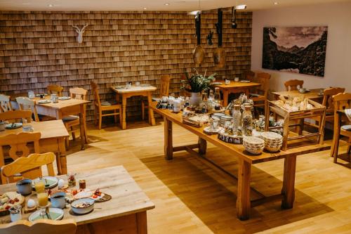 uma sala de jantar com mesas e cadeiras de madeira em Gästehaus Alpenhorst em Oberstdorf