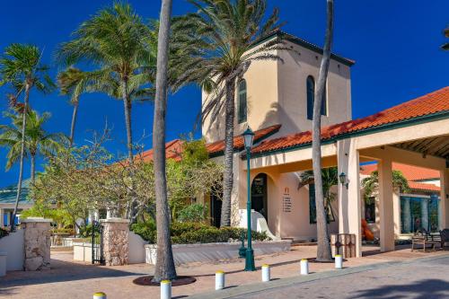 a building with palm trees in front of it at Luxury Pool Villa with View Cabana BBQ 3minBeach in Tierra del Sol in Malmok