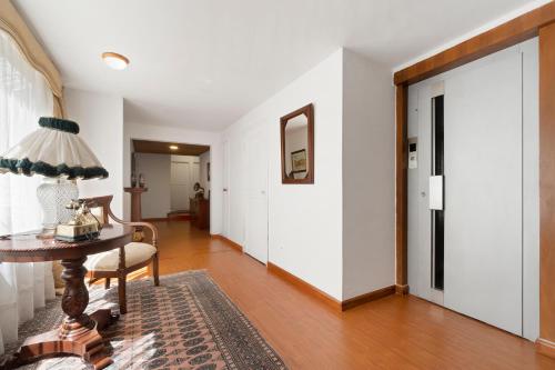 un pasillo con paredes blancas y una mesa con lámpara en Habitación 4 independiente con baño privado Unicentro, en Bogotá