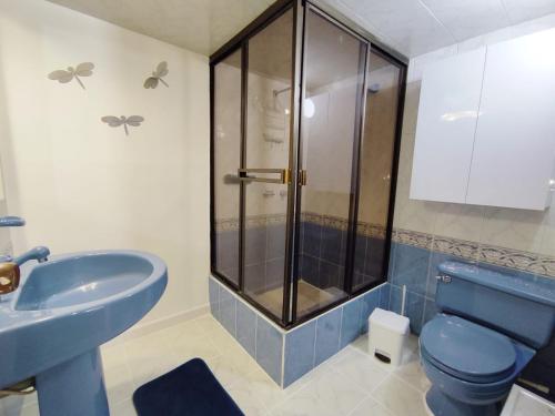 a bathroom with a blue toilet and a shower at Habitación 4 independiente con baño privado Unicentro in Bogotá