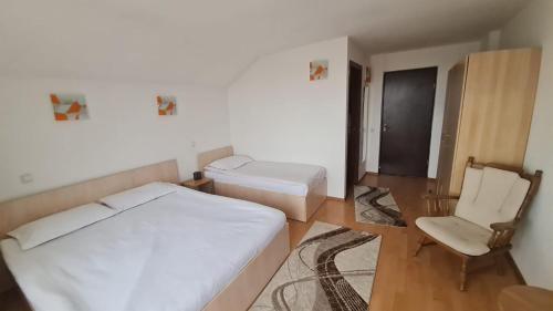 a small bedroom with a bed and a chair at Pensiune Runcu Stone in Runcu