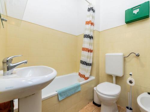 a bathroom with a sink and a toilet and a bath tub at Akisol Faro Sunny in Faro