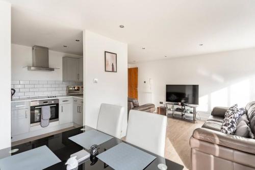 a living room with a couch a table and a kitchen at Stunning Flat by Quayside with Balcony!! in Newcastle upon Tyne