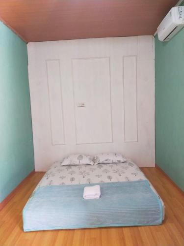 Mandeh Guesthouse Padang في بادانج: سرير في غرفة ذات مرتبة زرقاء