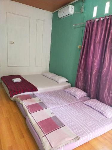 パダンにあるMandeh Guesthouse Padangのベッド2台が隣同士に設置された部屋です。