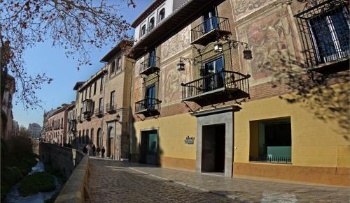 a cobblestone street in front of a building at El Ladrón De Agua Palacete in Granada