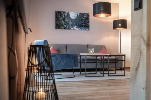 a living room with a couch and a table at Forstgut - Premium Waldchalets und Lodge Suiten in Regen