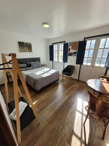 a bedroom with a bed and a table and chairs at Bahia Pelô Hostel in Salvador