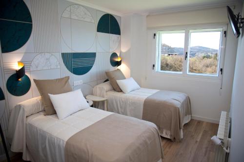 a hotel room with two beds and a window at Pension Casa Manolo in Fonsagrada