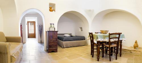 un soggiorno con letto, tavolo e sedie di Il Trullo del viaggiatore ad Alberobello