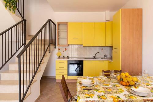 eine Küche mit gelben Schränken und einem Tisch mit Lebensmitteln in der Unterkunft Villa vista mare ~Villa Dafne~ in Noto Marina