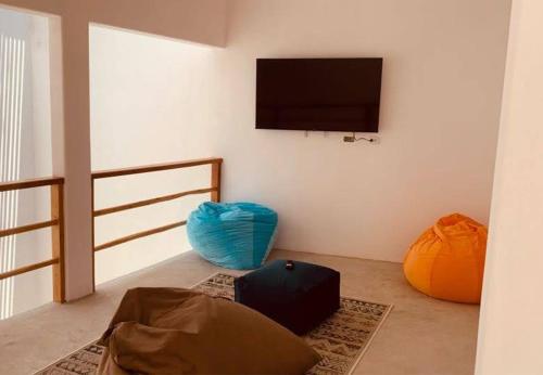 a living room with a flat screen tv on a wall at Casa GAIA - Punta Sal in Canoas De Punta Sal