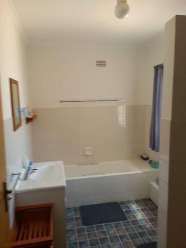 a white bathroom with a tub and a sink at Yzerzee 2 in Yzerfontein