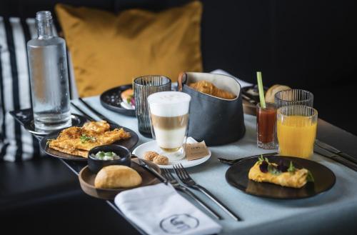a table with plates of food and drinks on it at LUA Boutique RoomZ- Adults only in Balatonfüred