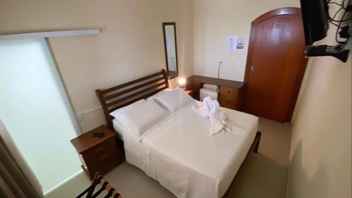 a small bedroom with a white bed in a room at Espaço Nobre in Cunha