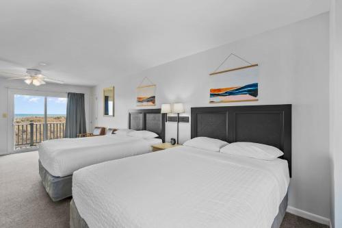 ein Hotelzimmer mit 2 Betten und einem Balkon in der Unterkunft The Beach House in Carolina Beach