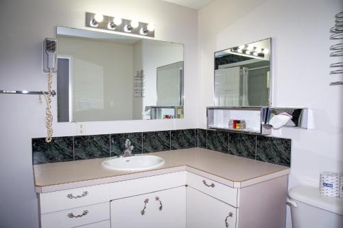a bathroom with a sink and a mirror at Spanish Villa Resort in Penticton