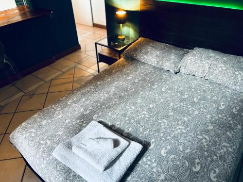 a bed with two towels sitting on top of it at Piazza Verdi Apartment in Bologna