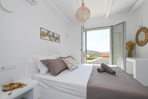 una camera da letto bianca con un letto e una finestra di Xerolithia suites a Agios Sostis