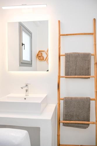 a bathroom with a sink and a mirror at Xerolithia suites in Agios Sostis