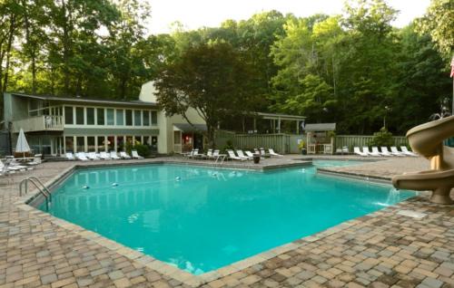 a swimming pool with blue water in front of a house at The Overlook - '21 Cabin - Gorgeous Unobstructed Views - Fire Pit Table - GameRm - HotTub - Xbox - Lots of Bears in Gatlinburg