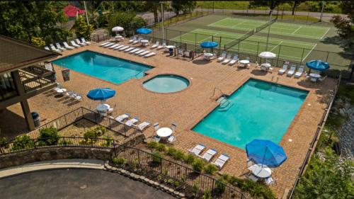 an overhead view of two pools with chairs and a tennis court at The Overlook - '21 Cabin - Gorgeous Unobstructed Views - Fire Pit Table - GameRm - HotTub - Xbox - Lots of Bears in Gatlinburg