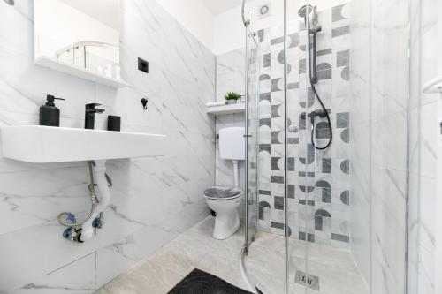 a white bathroom with a shower and a sink at Apartment Lusy Lo in Zadar