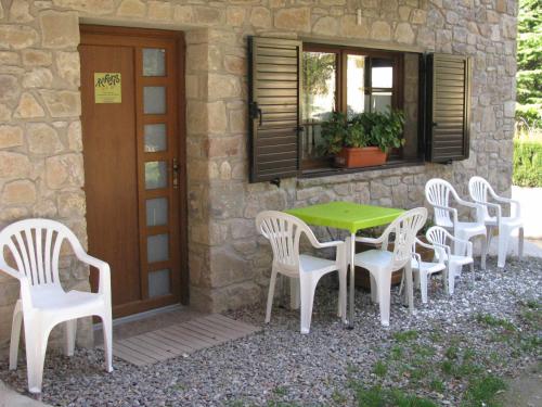 une table et des chaises assises à l'extérieur d'une maison dans l'établissement AlpensHolidays Les Pallissses, à Alpens