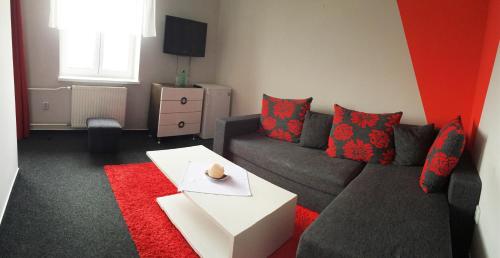 a living room with a couch and a red rug at Hotel Sonata in Hradec nad Moravici