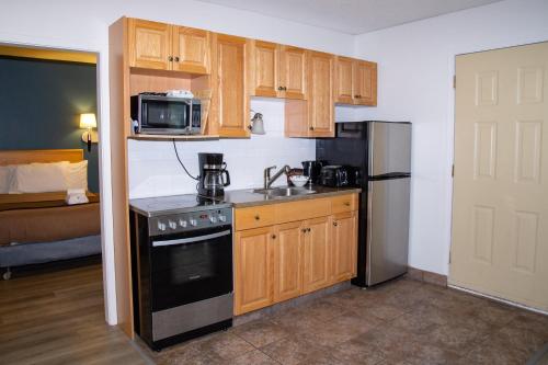 a small kitchen with a stove and a microwave at Spanish Villa Resort in Penticton