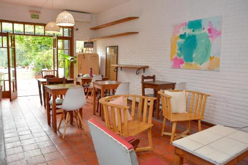 un restaurante con mesas y sillas de madera y ventanas en Hostel Posada Juan Ignacio en Rosario